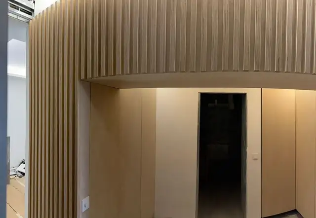Detalle del remate curvo superior en un revestimiento de listones de madera a medida
