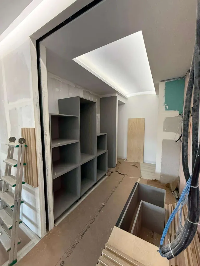 Mobiliario a medida instalado en una vivienda en reforma, con estantería de suelo a techo