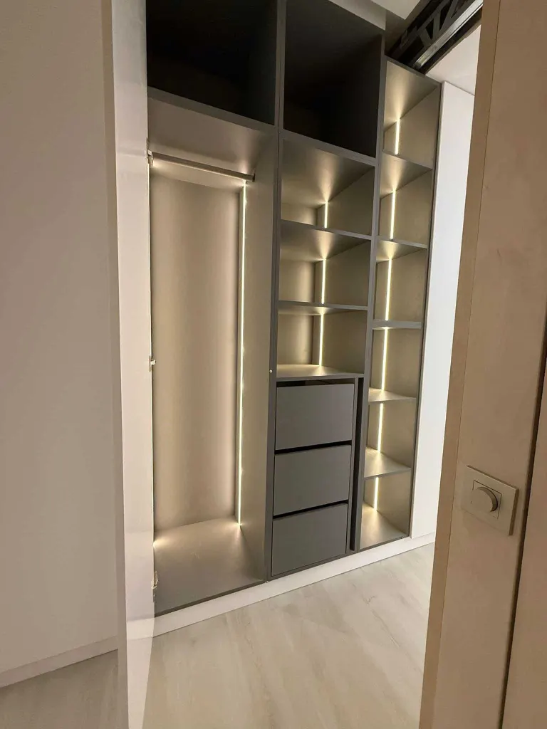 Vestidor a medida terminado con baldas iluminadas por LED, cajonera interior y barra de colgar