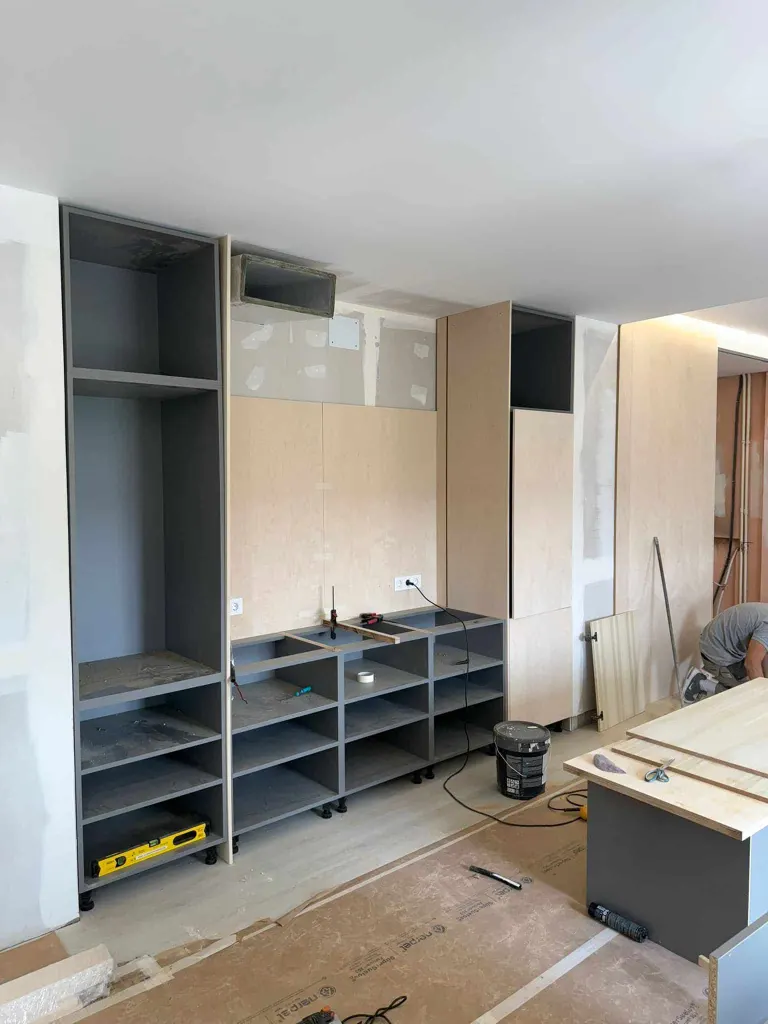 Montaje de cocina y armarios a medida en obra, con módulos nivelados y frentes de madera clara
