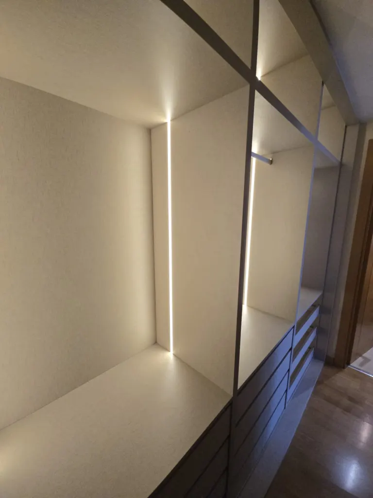 Proyecto integral a medida en listones de madera, lacado blanco mate, led en hornacina y estantería · Madrid · CMM