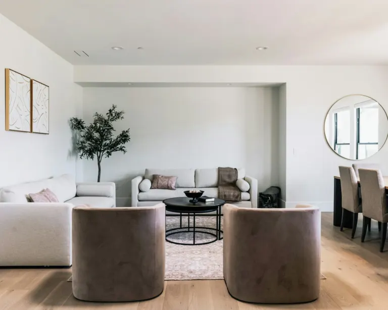 Salón amplio con sofás claros y suelo laminado de aspecto roble claro
